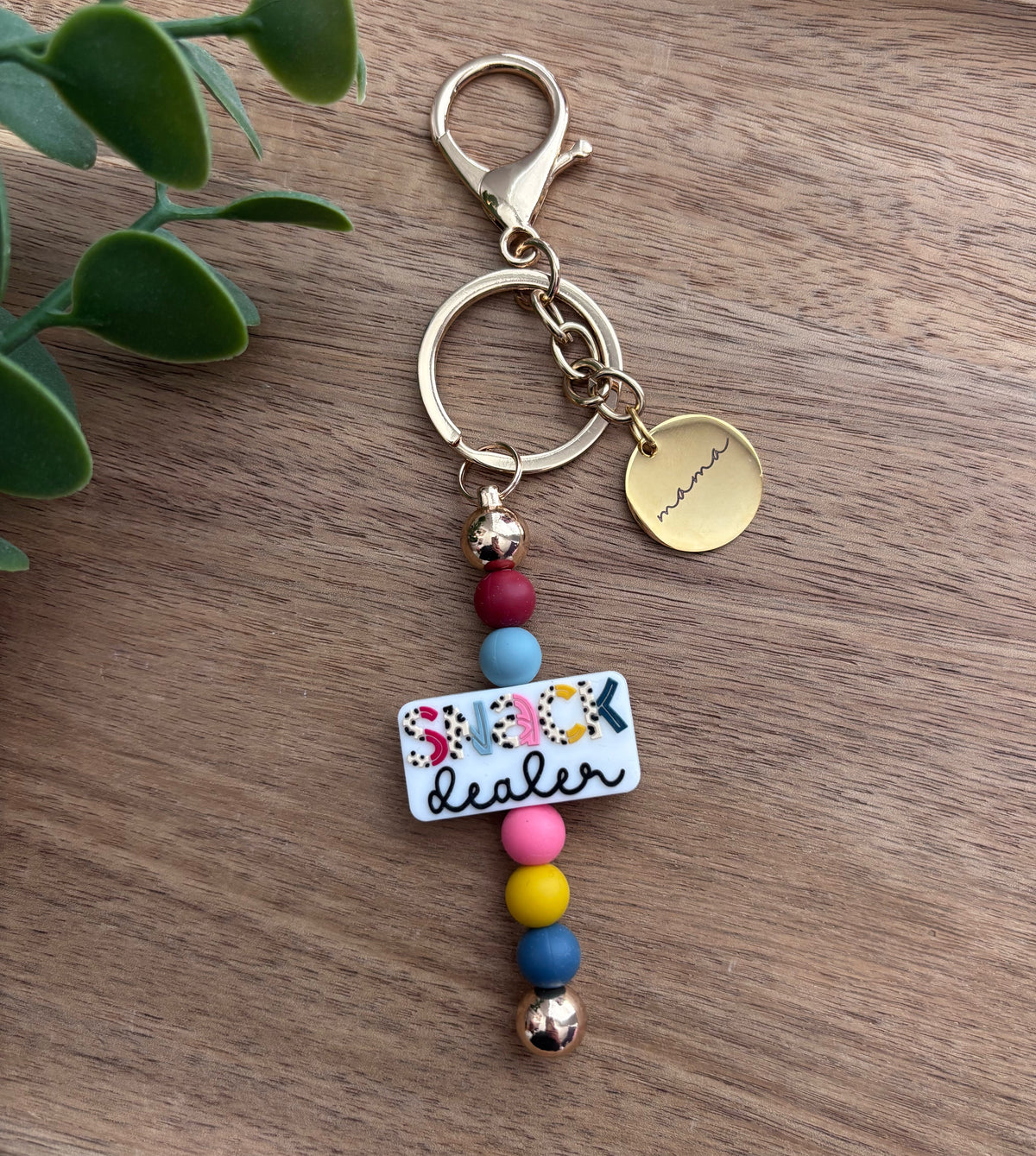 Keychain with colorful beads and a tag on a wooden surface