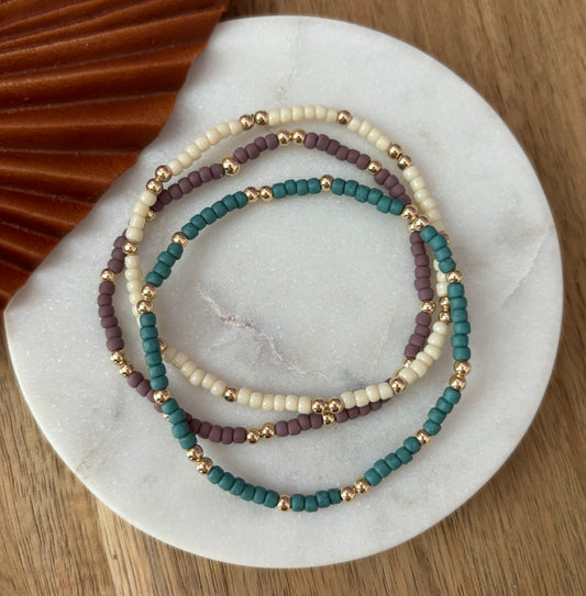 Image of a stack set of three beaded bracelets featuring boho seed beads and gold filled beads, very trendy and minimalist