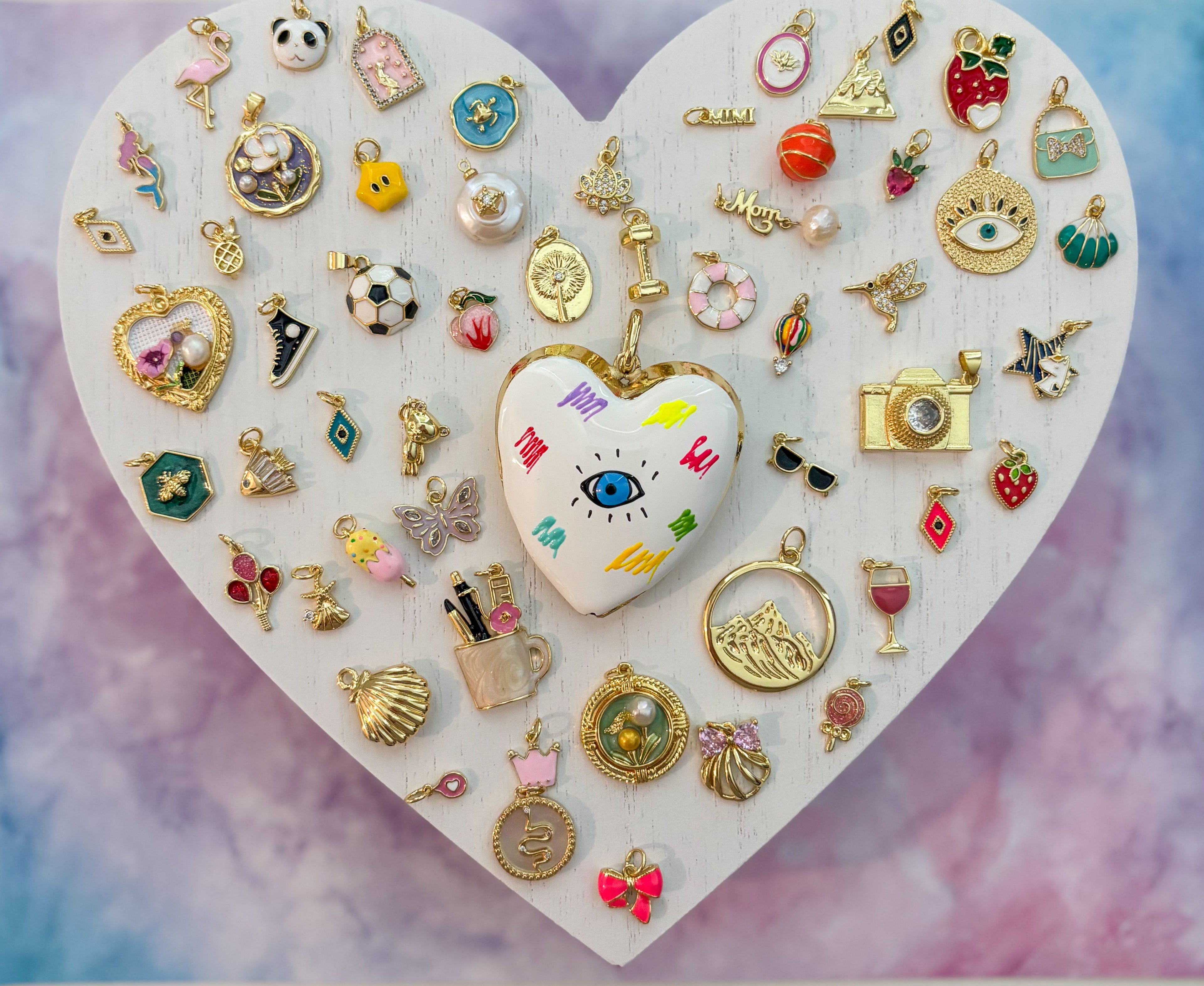 Collection of various small charms on a heart-shaped stand with a colorful background
