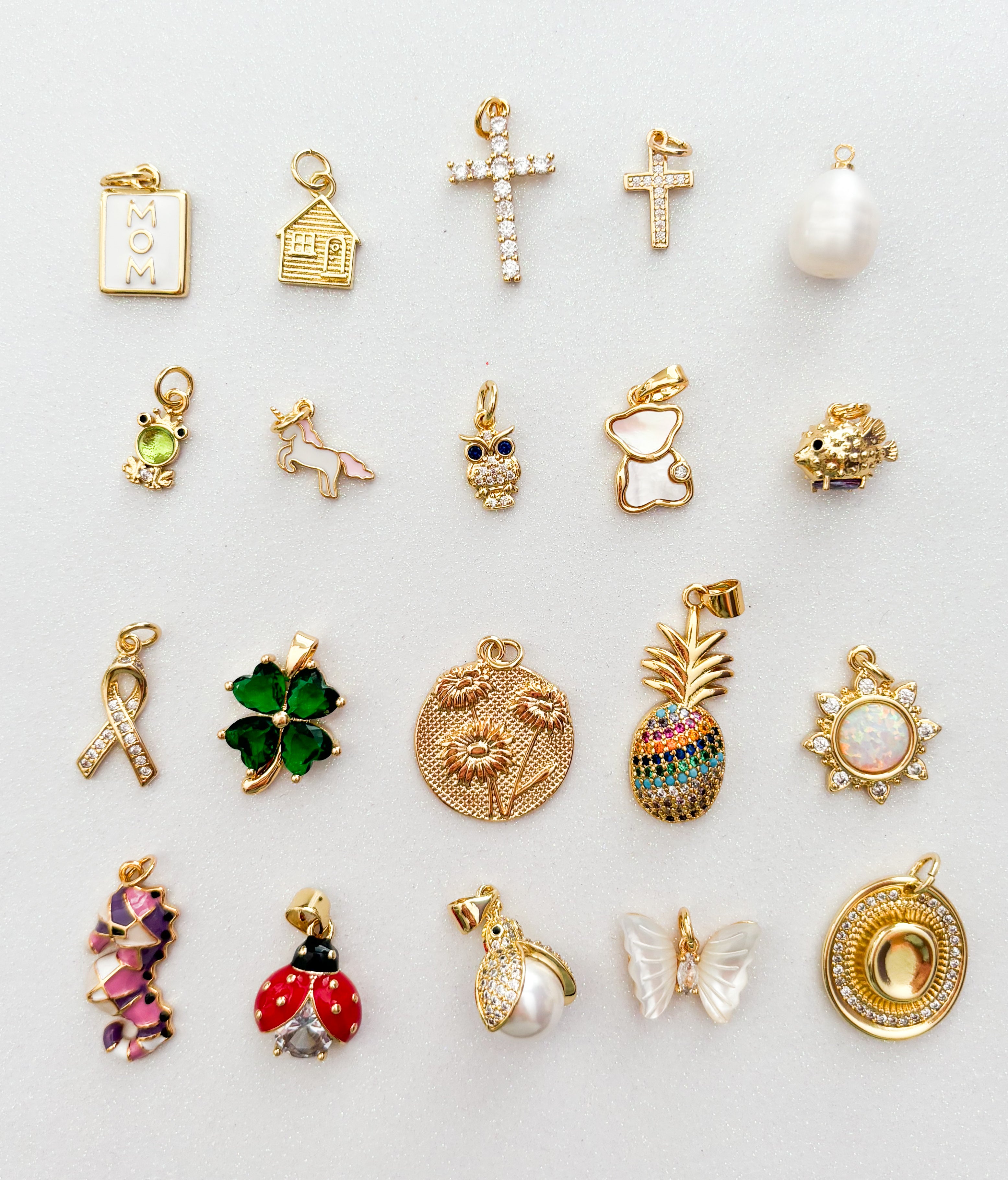 Collection of various gold charms on a light background