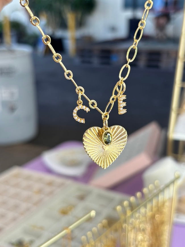 Gold necklace with heart pendant on a blurred background