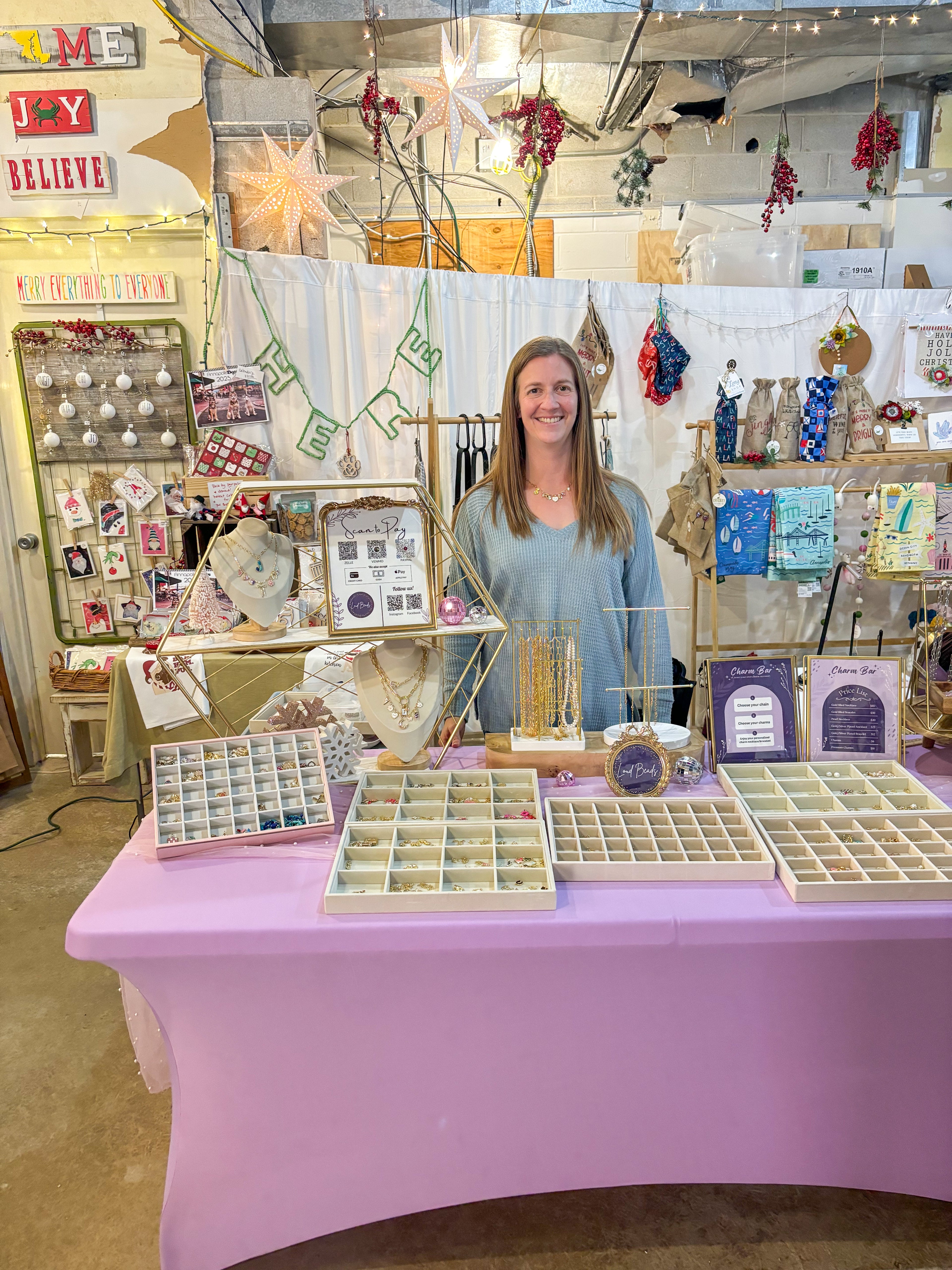Woman standing behind a table with display cases in a small shop