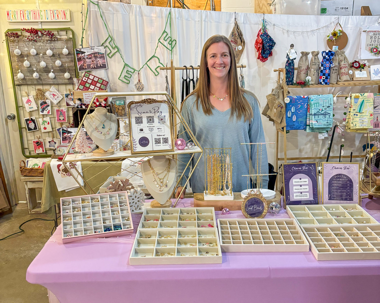 Woman standing behind a table with display cases inside a small shop