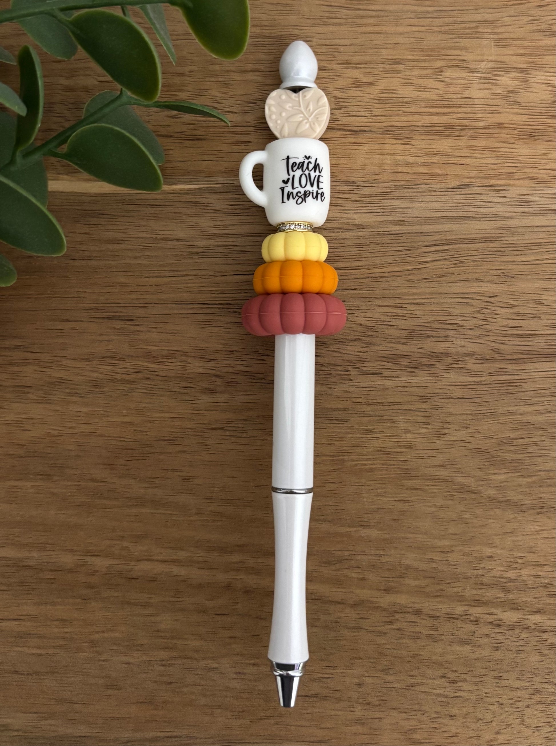 Decorative pen with colorful beads on a wooden surface