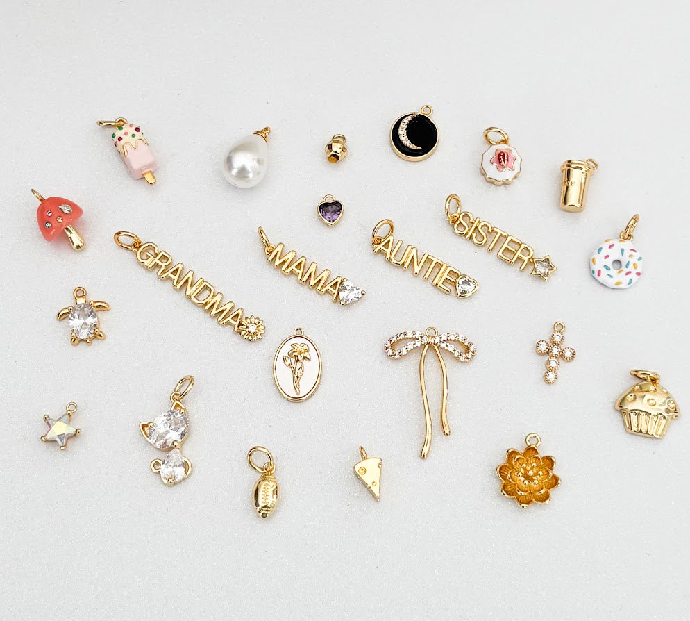 Collection of various gold charms on a light gray background