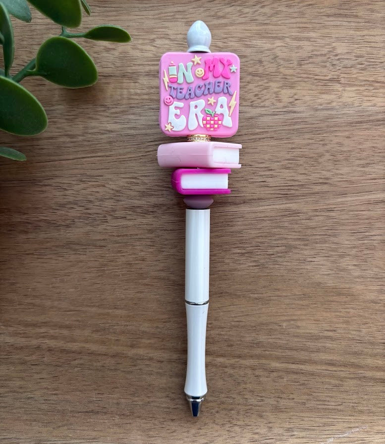 Decorative pen with pink top and white body on a wooden surface