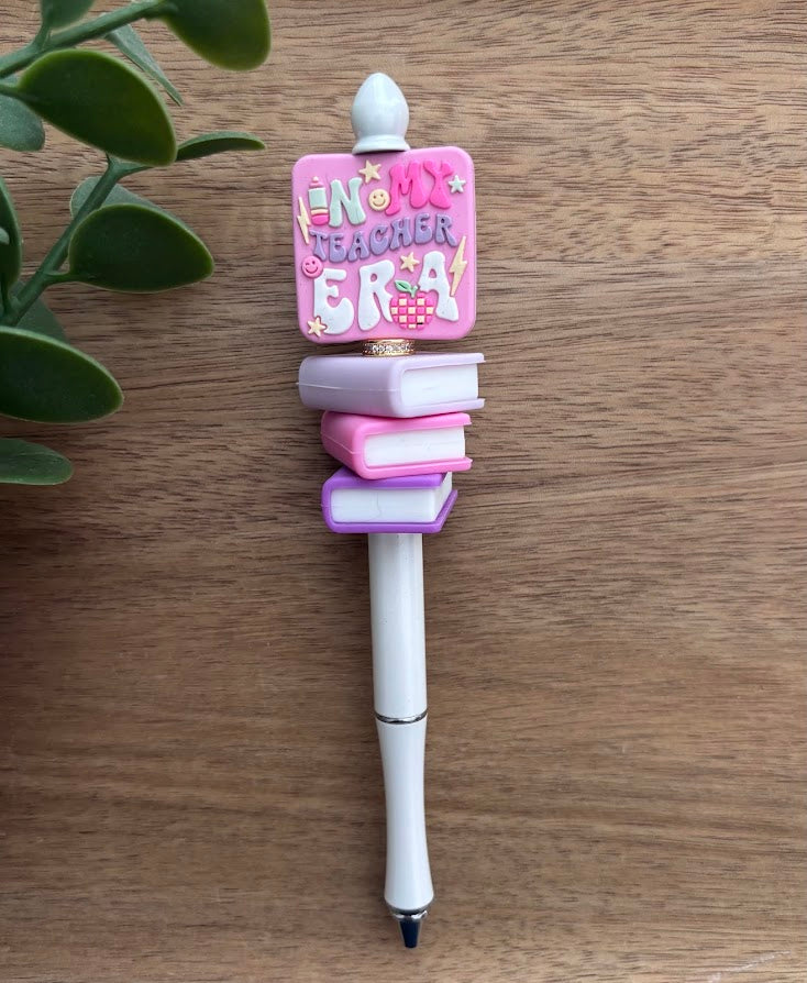 Decorative pen with a pink and white design on a wooden surface